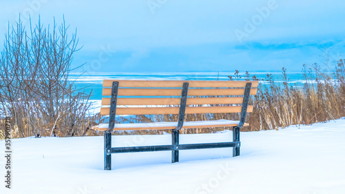 Panorama Back view of outdoor bench overlooking Utah Lake and cloudy sky over the horizon