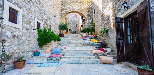 Stairs with pillows and stone arch in Ulcinj Old Town, Montenegro. Banner and panoramic edition. Selective focus. photo