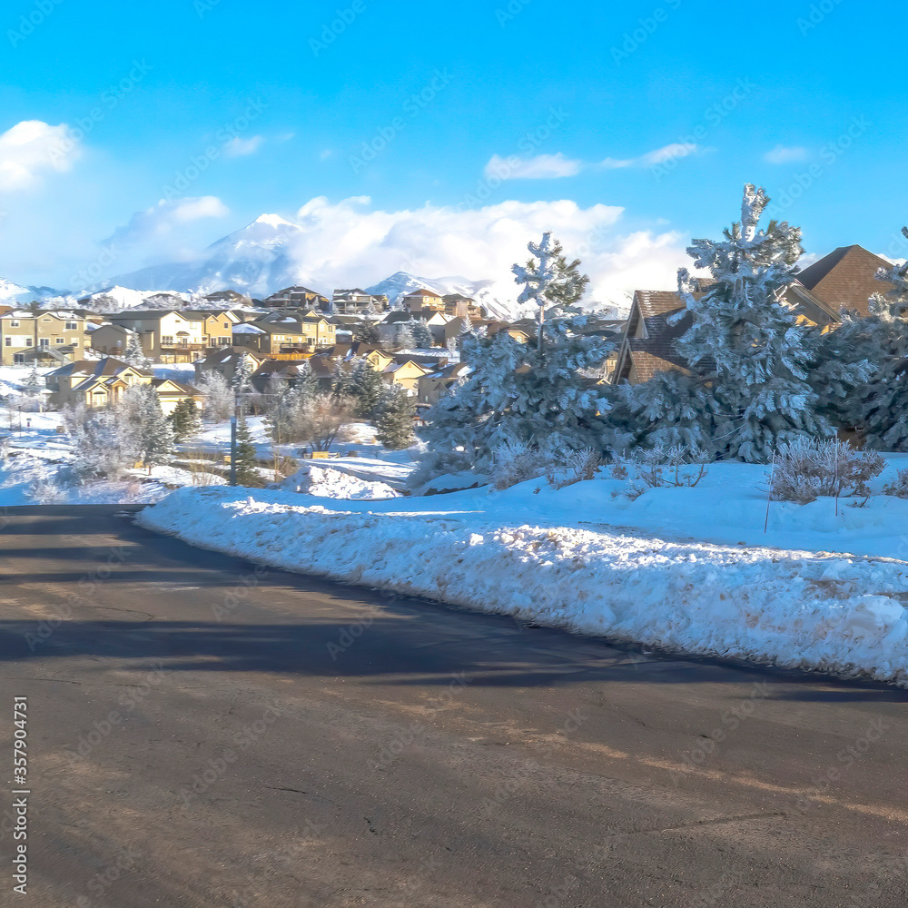 Square Scenic town in Wasatch Mountain with a road along houses on snowy terrain