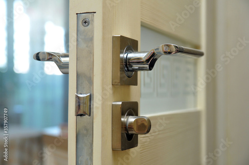 Modern style doorknob on a wooden door. Door lock