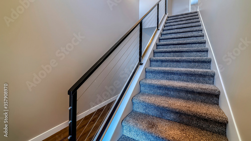 Canvas Print Panorama Indoor stairs of home with metal handrail and gray carpet on the treads