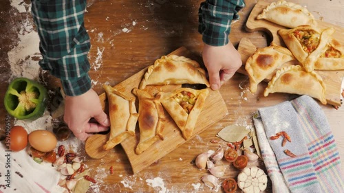 Man cooking empanadas argetinian pie, traditional bakery from argentina, chef filling dough in home with meat and vegetables, homemade spanish empanadas photo