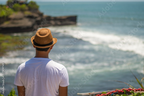A solo male traveller in blue dress is enjoying the beautiful seascape with horizon of Tanh lot in Bali © Souvik