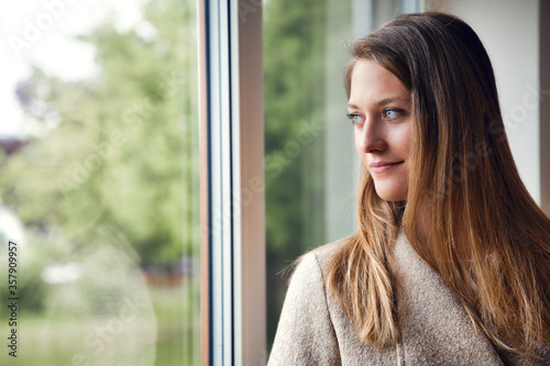 Gorgeous young woman looks out the window Free Download Gorgeous young woman looks out the window - GFXLoad