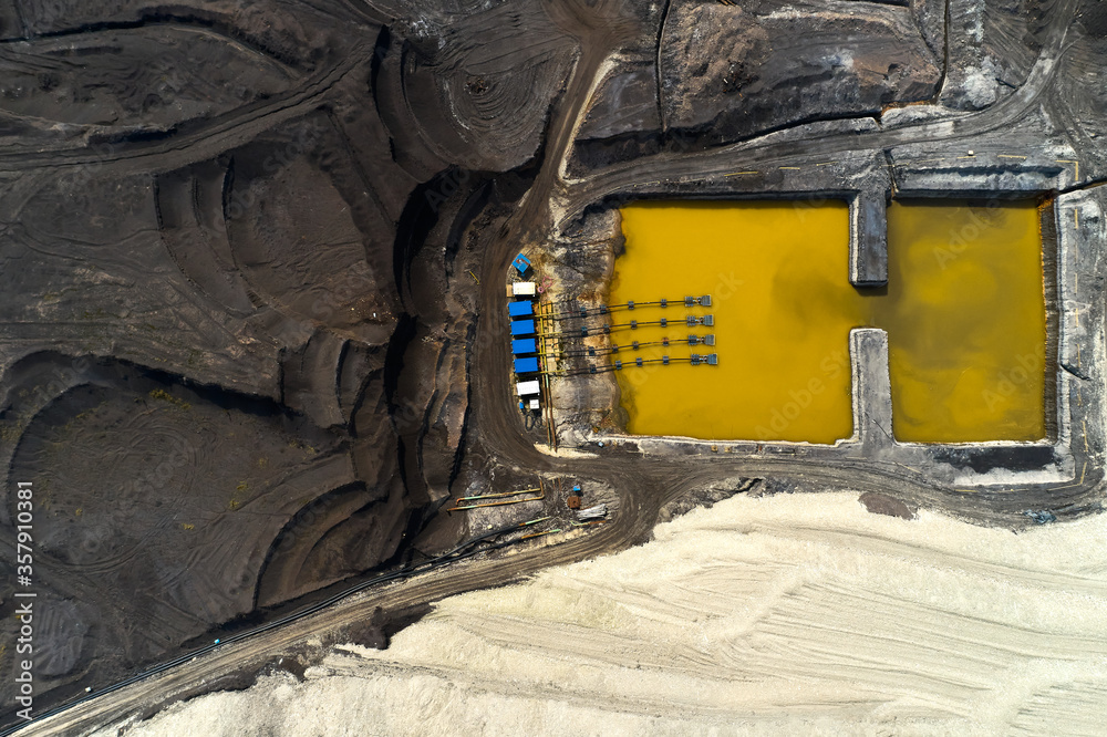 Top view on a pool with yellow liquid used in a coal mining in a quarry. Heavy industry concept