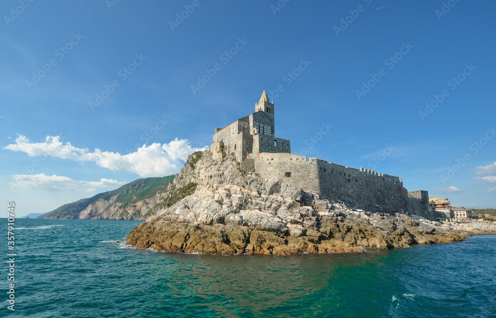 The imposing Church of St. Peter and the Doria Castle on the rocky peninsula at the entrance to Porto Venere Italy on the Ligurian Coast.