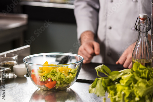 Fototapeta Naklejka Na Ścianę i Meble -  Healthy fresh salad on kitchen table. Closeup mixed vegetables in glass bowl.