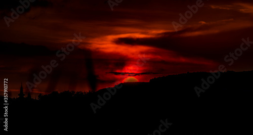 Red fresh sunset with dark clouds near Rakvice village in summer evening