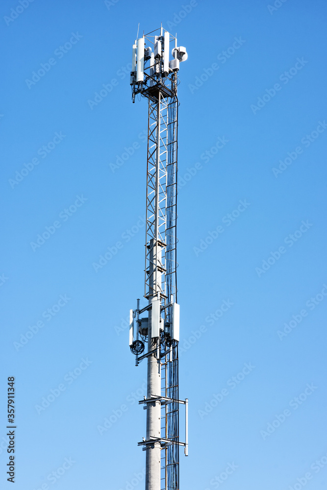 Cellular antenna tower on background of blue sky.