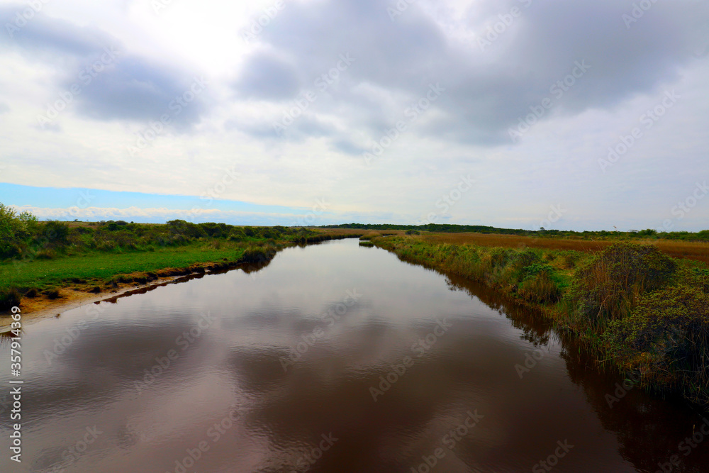 Scenic view over a small lake in a Dutch national park on a Wadden island. Scenic view over a small lake in a Dutch national park on a Wadden island.