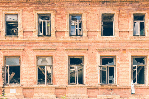 Collapsed roof and broken windows in an old brick building. Abandoned residential building