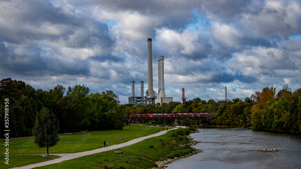 Obraz premium Blick über einen Fluss auf ein Heizkraftwerk in der Stadt