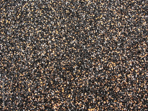Beige-black-white stone gravel background texture. Brown small rocks abstract road pavement pattern