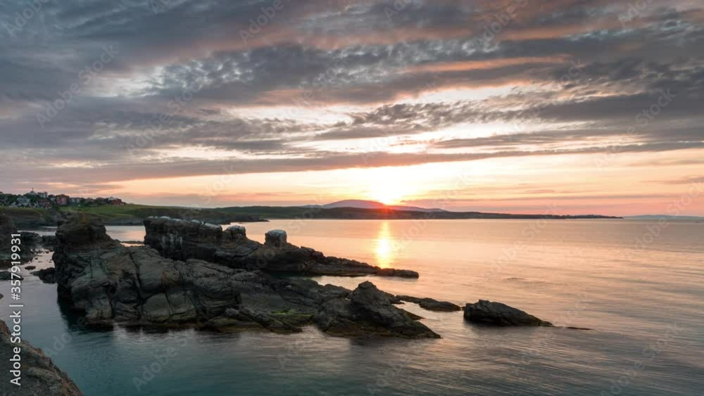 Time lapse with colorful sunset sky at rocky coastline and calm summer sea, the Black Sea coast, Bulgaria Time lapse with colorful sunset sky at rocky coastline and calm summer sea, the Black Sea coast, Bulgaria
