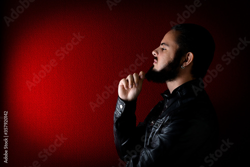 portrait of a young beard man on a red background