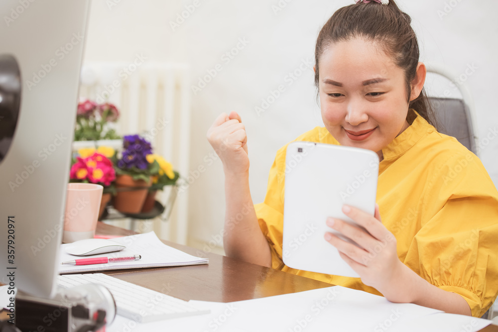 Working at home lifestyle young woman is business from the home office, happy for working in the room, using a computer, mobile phone or laptop on the desk in the room decorated with beautiful flowers Working at home lifestyle young woman is business from the home office, happy for working in the room, using a computer, mobile phone or laptop on the desk in the room decorated with beautiful flowers