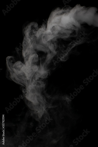 A stream of white smoke on a black background mixes randomly creating bizarre swirl patterns