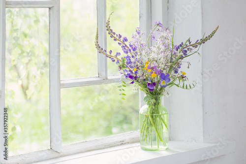 Papier peint wild flowers in vase on white windowsill