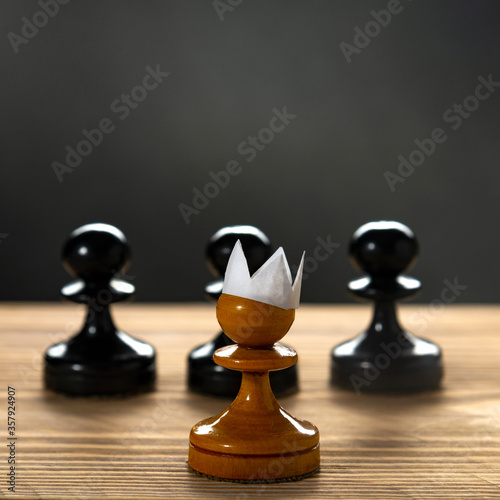 Small courageous pawn with an artificial paper crown suit  leading others into battle with the enemy - business entrepreneur leadership concept. Black lives matter