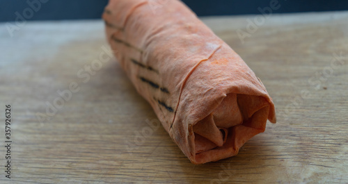 Shawarma  fresh roll of lavash, chicken beef shawarma falafel, grilled meat, mushrooms, cheese. Traditional Middle Eastern snack. On wooden background. photo