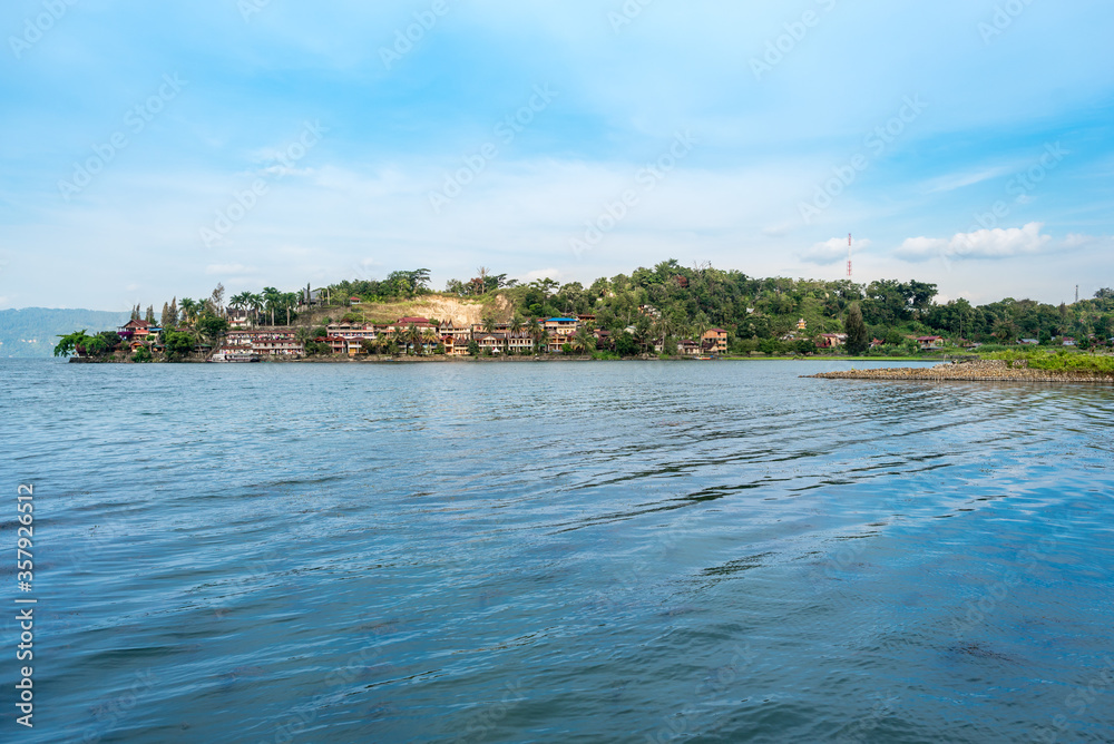 The north-west shore of the peninsula Tuktuk with the tourist resorts as part of the island of Samosir in North Sumatra within the Lake Toba