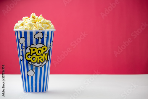 Baked Butter Popcorn into a blue striped paper cup, roasted Butter Corn Kernels Mixed with natural salt, Appetizers in the cinema or party