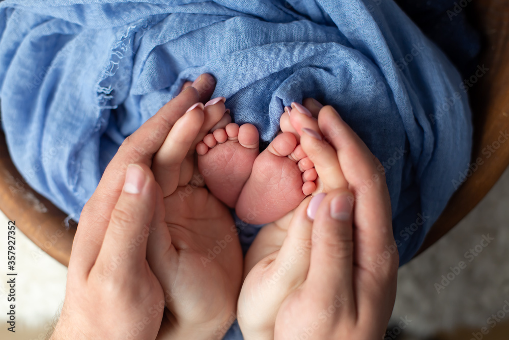 little feet a newborn baby boy. Legs on blue background, ,soft focus