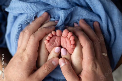 little feet a newborn baby boy. Legs on blue background, ,soft focus photo