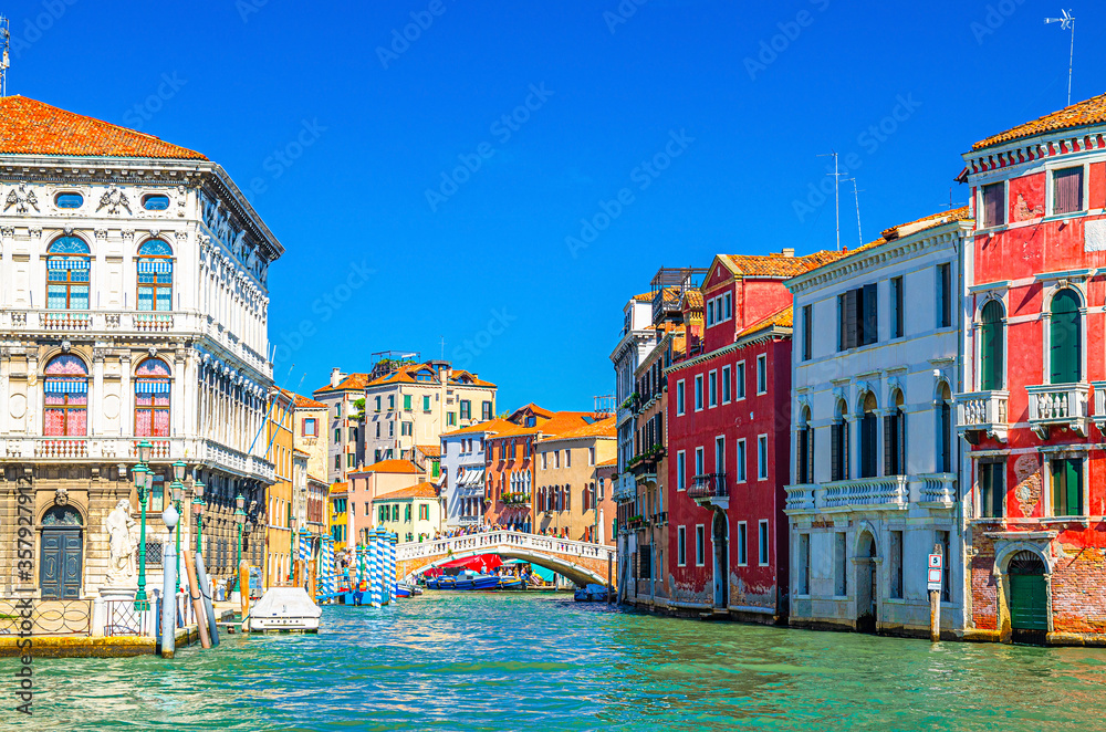 Venice Grand Canal waterway cross Cannaregio Canal with Palazzo Labia palace, Ponte delle Guglie bridge and colorful buildings, blue clear sky background in summer day, Veneto Region, Italy