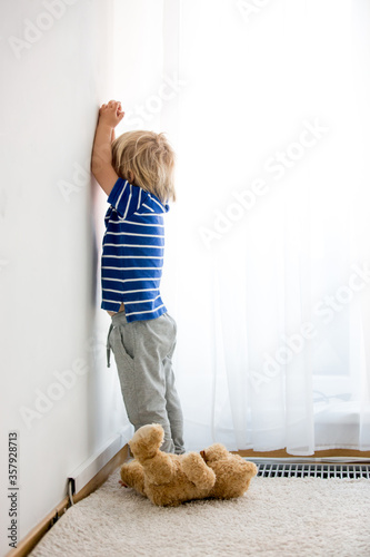 Child, toddler boy, punished in the corner for mischieves