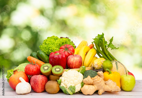 Assortment of Fresh vegetables and fruits With vitamins c from bananas, kiwi, grapes, raspberries, blueberries, and blackberries, good for the body and diet food on the table in nature background.