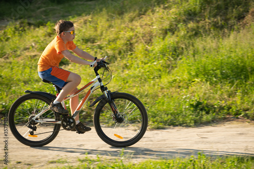 Teenager riding a bicycle, closeup, selective focus