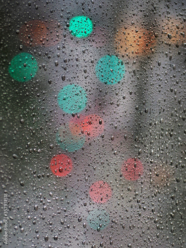 Gotas de lluvia en una ventana con luces de cuidad de fondo
