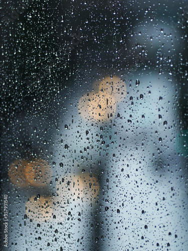Gotas de lluvia en una ventana con luces de cuidad de fondo