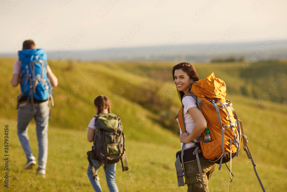 Happy trip family with backpacks is walking in nature. Camping in the nature.
