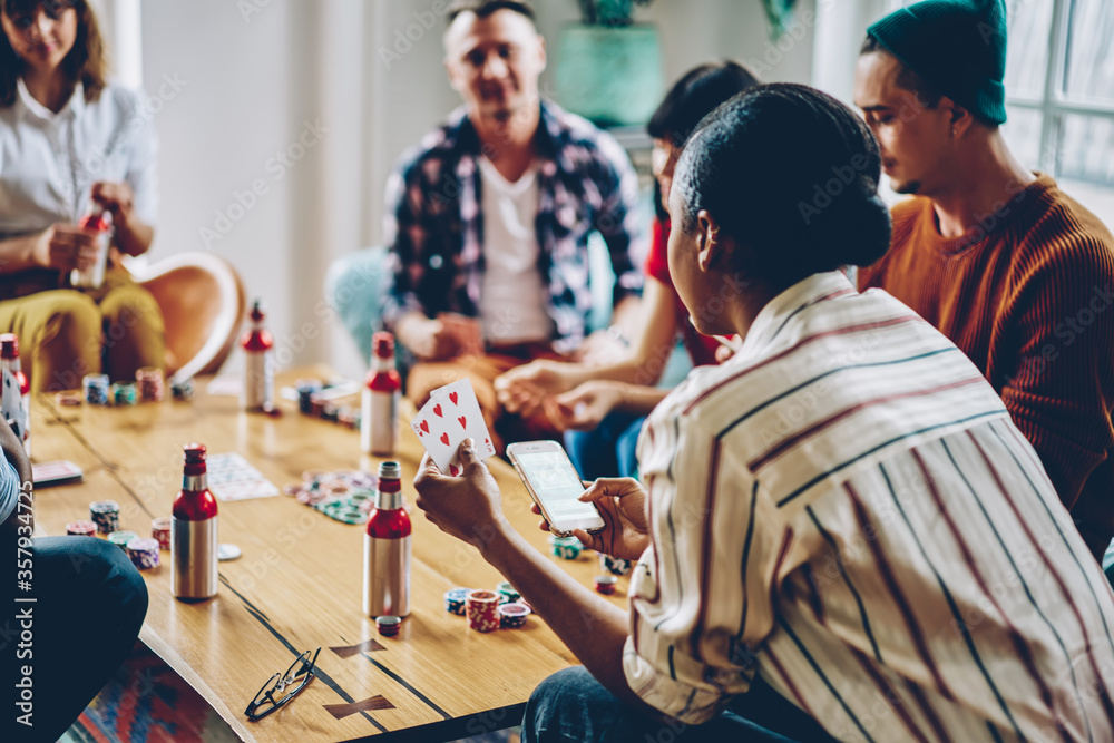Black woman playing poker with friends in room