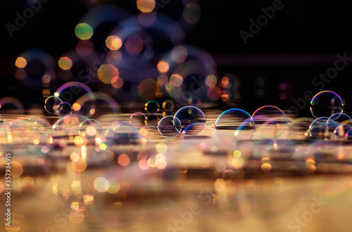 festive background with lots of shiny iridescent soap bubbles and highlights ...