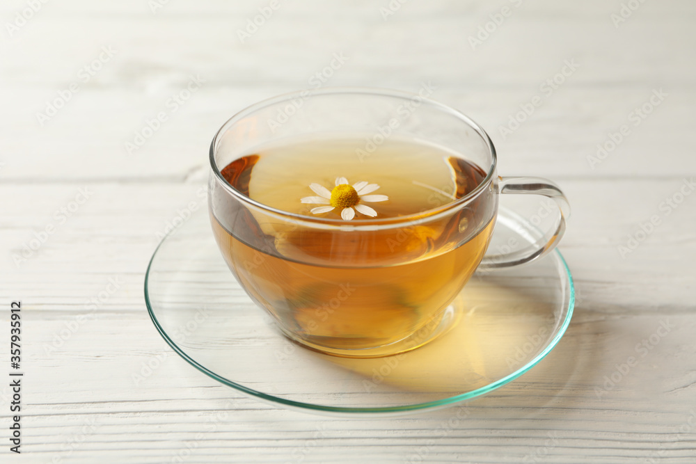 Glass cup of chamomile tea on wooden background, close up Glass cup of chamomile tea on wooden background, close up