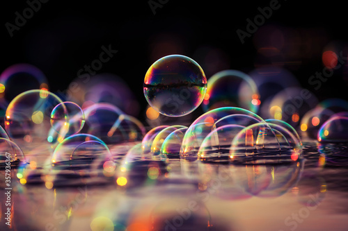 decorative space background with many sparkling iridescent soap bubbles float...