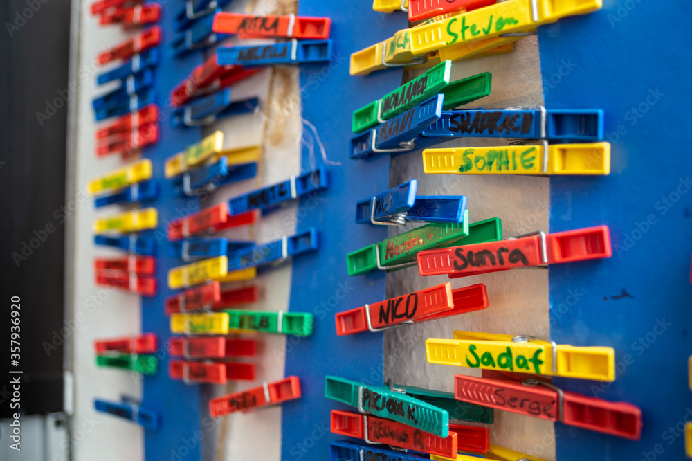 colorful clothes pegs with name tags as a creative work plan and duty