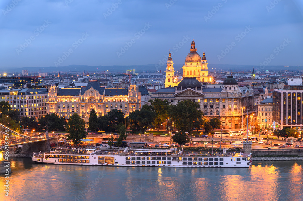 A ferry boat passes along the eastern shore of the River Danube in Budapest past the Parliament building