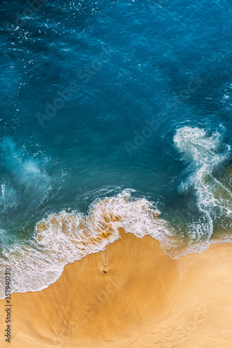 Beautiful sandy beach with blue, vertical view. Drone view of tropical blue ocean beach Nusa penida Bali Indonesia. Lonely sandy beach with beautiful waves. Beaches of Indonesia. Copy space