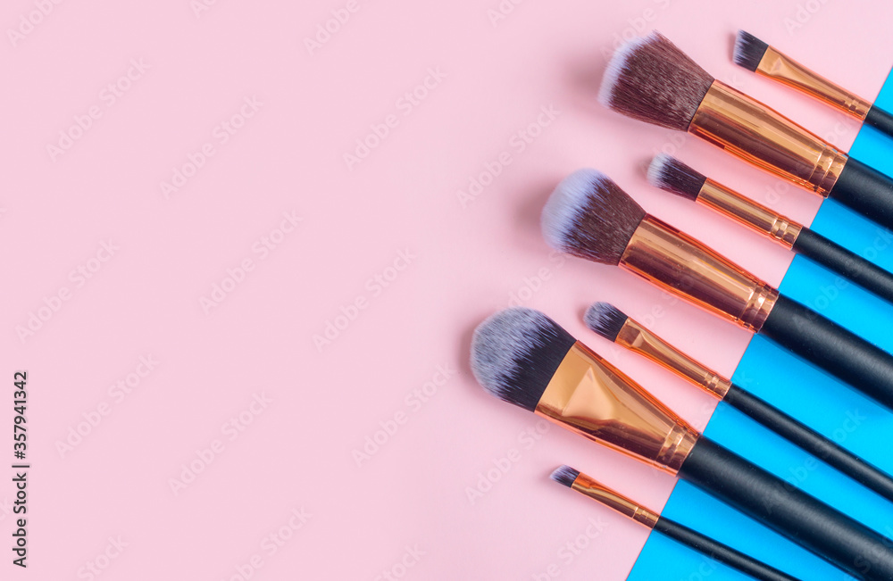 premium makeup brushes on blue and pink background, creative cosmetics flat lay, tools for make up, copy space premium makeup brushes on blue and pink background, creative cosmetics flat lay, tools for make up, copy space