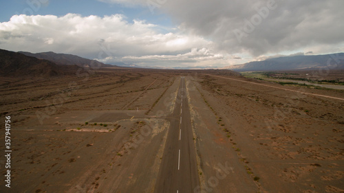 Travel. Asphalt highway across the arid desert. Wide empty road into the mountains.