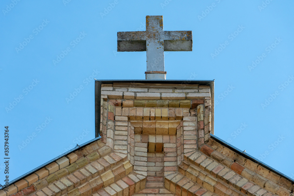 A large stone cross on the roof of an old Church