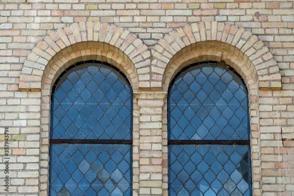 Obraz premium Old vintage window on a brick building. Arched windows on the church.
