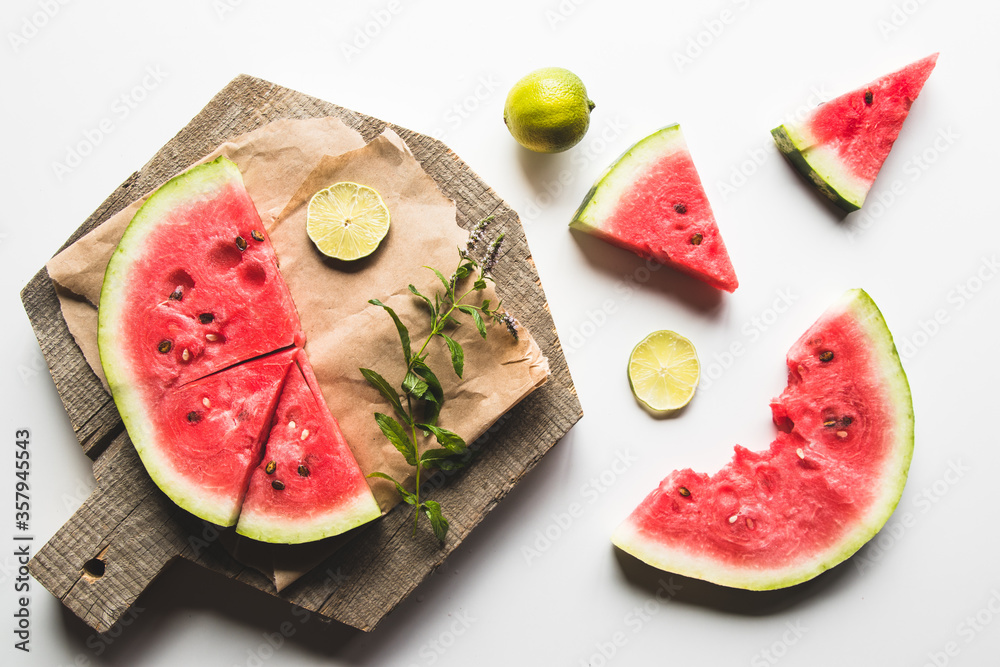 watermelon on a sliced board with mint and slices of lime. food watermelon on a sliced board with mint and slices of lime. food