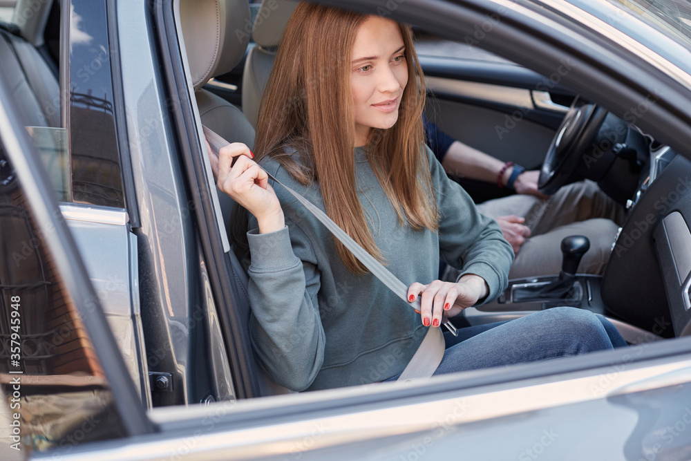 Charming female fastening herself with security belt Charming female fastening herself with security belt