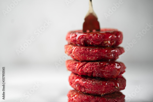 Close up of heesecakes with honey colored in red.Russian traditional breakfast. Food consept.Plate with puncakes on white marble background.Copyspace for text and design elements. Small depth of field photo