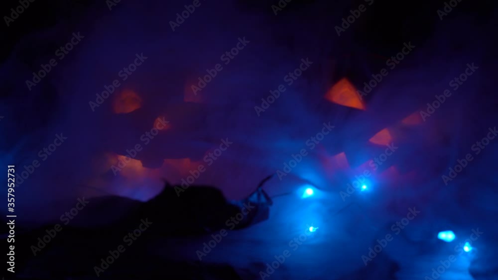 Halloween, two pumpkins with a scary face glowing inside, smoke passes from left to right in the dark at night. Halloween, two pumpkins with a scary face glowing inside, smoke passes from left to right in the dark at night.